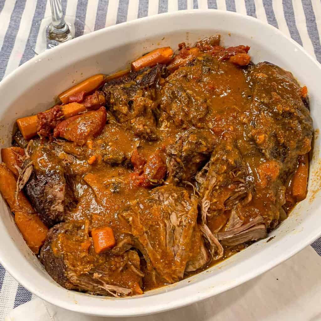 A casserole dish filled with brasato di manzo, Italian pot roast.