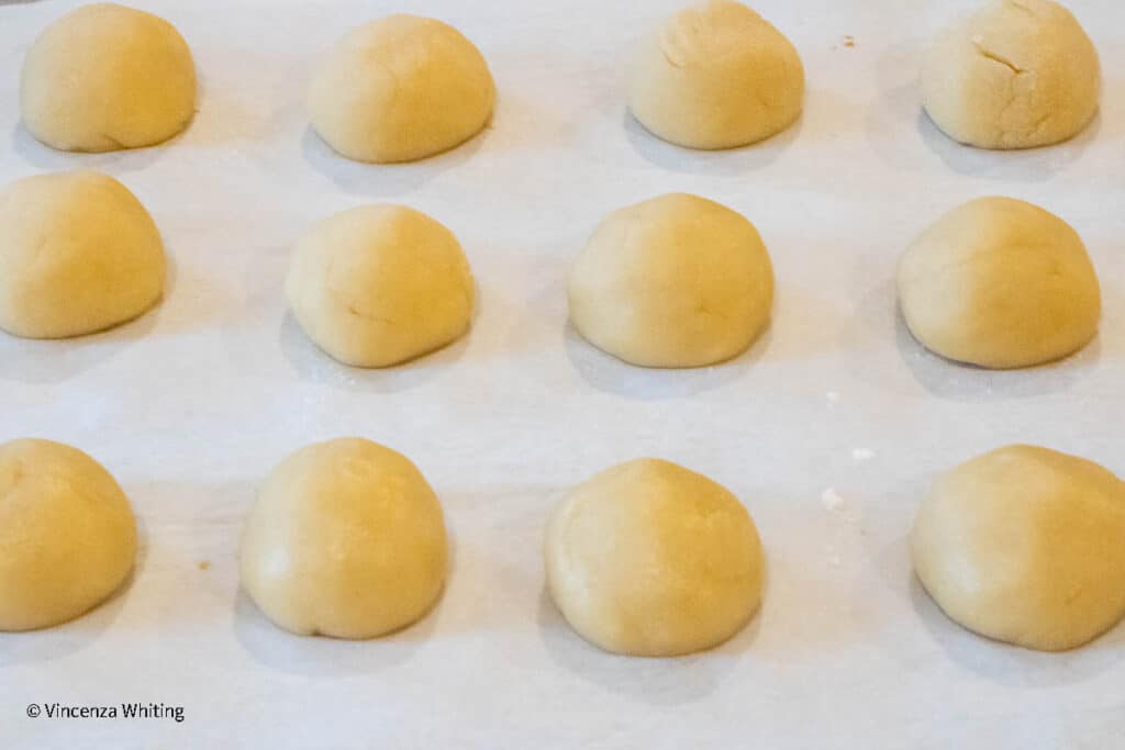 Cookie dough balls on a baking sheet.