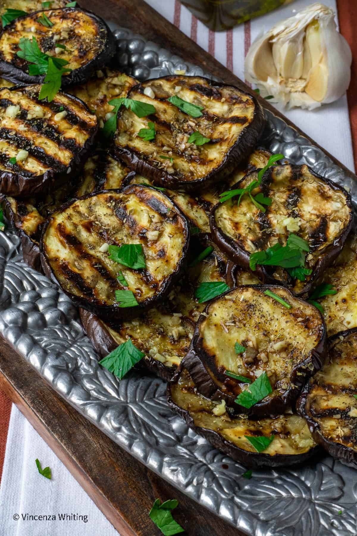 A silver tray of grilled eggplant slices.