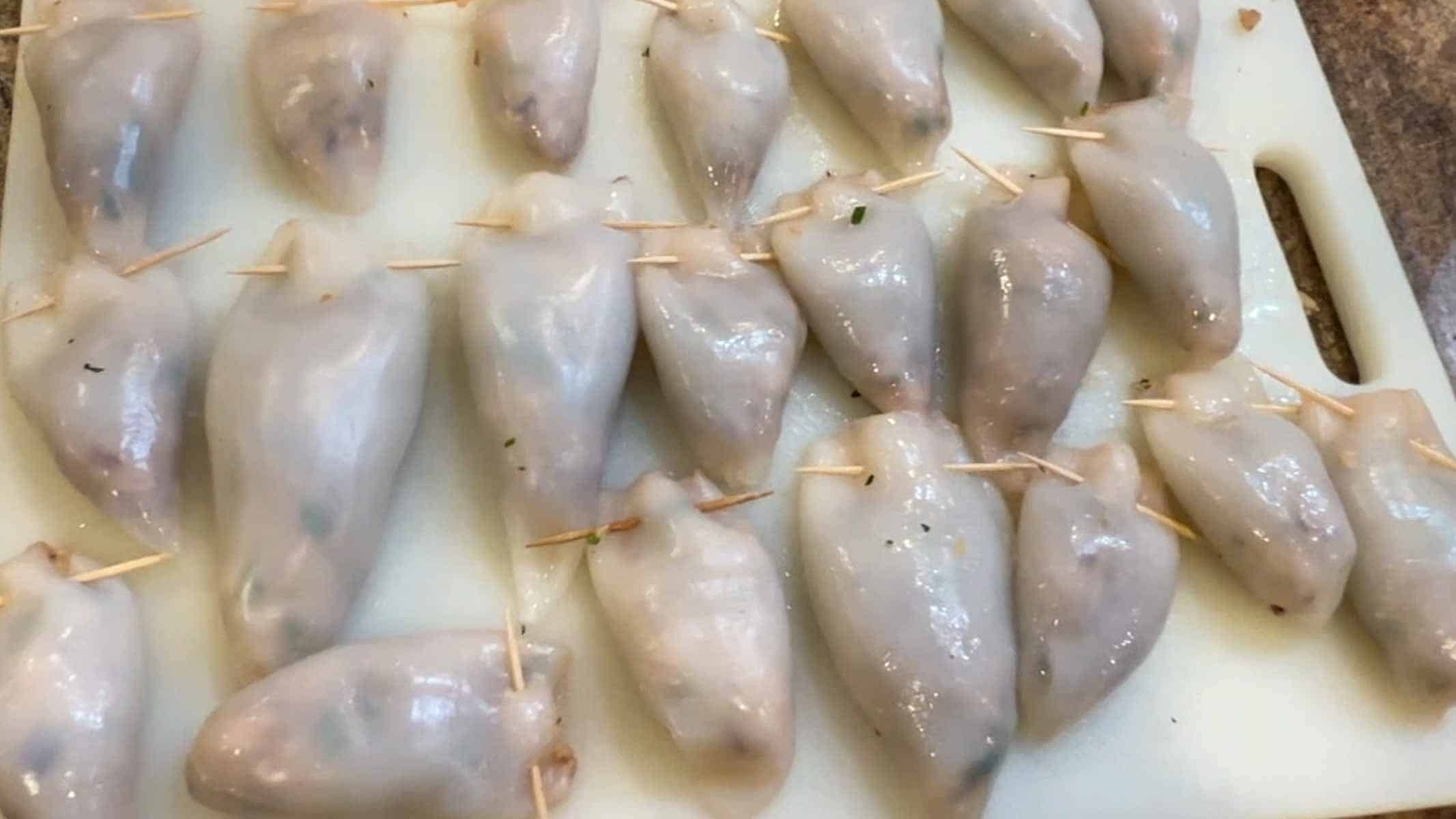 Stuffed calamari bodies sealed with toothpicks.