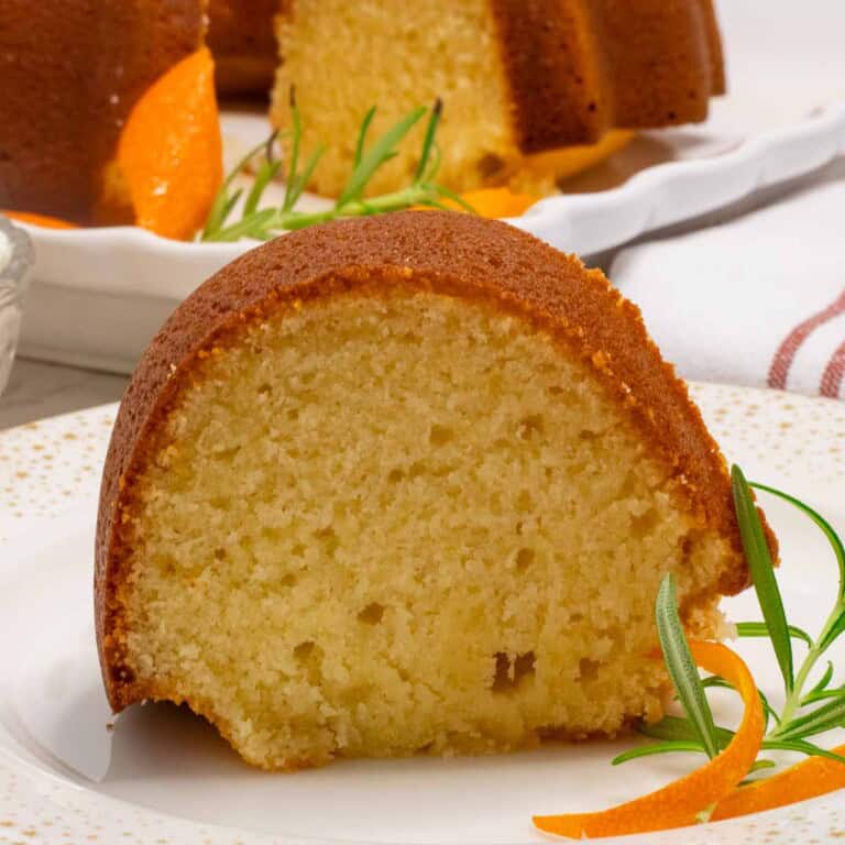 A slcie of Italian hangover Cake with an orange rind and rosemary sprig.