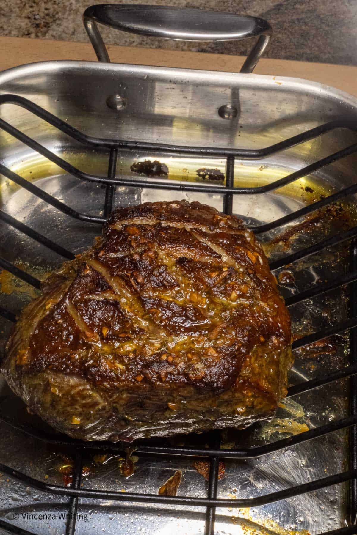 A perfectly roasted bottom round roast on a rack in a roasting pan.