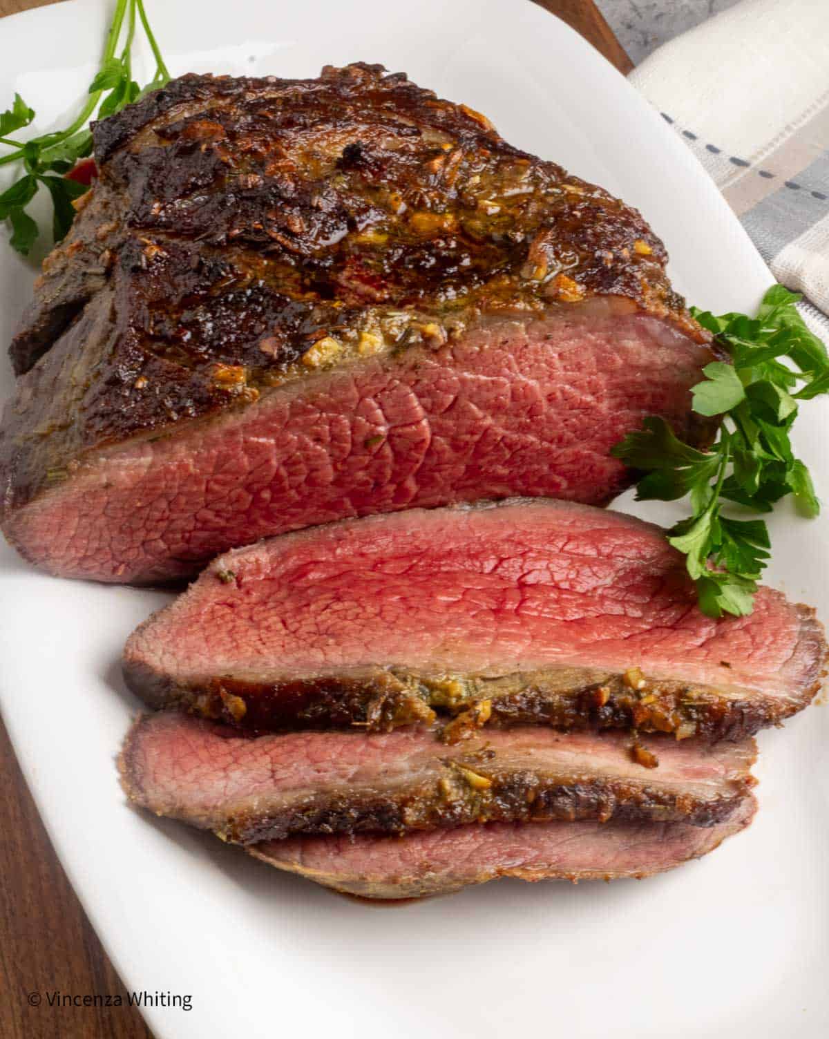 A medium rare bottom round roast that has been sliced.