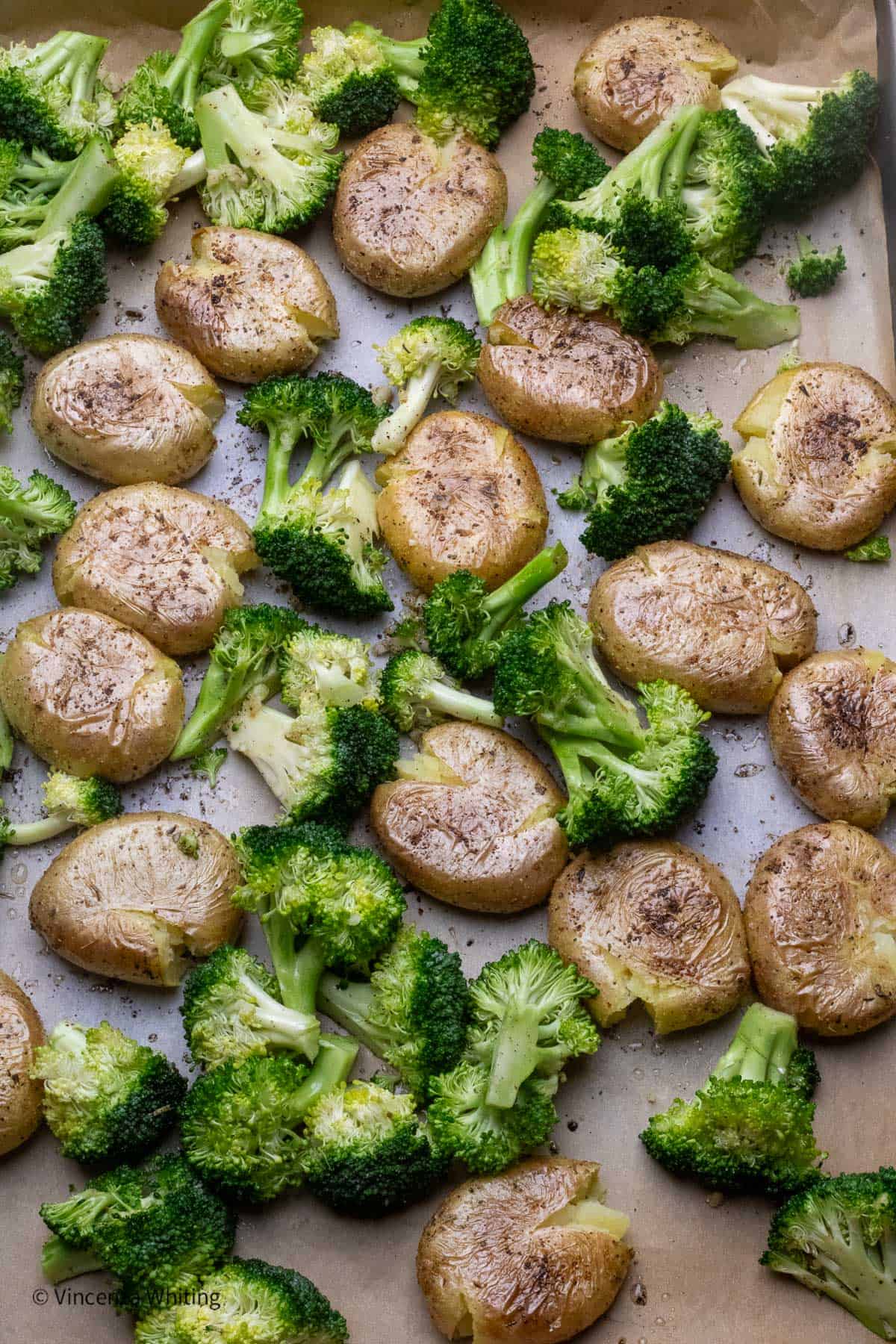Roasted broccoli and potatoes in a baking sheet.