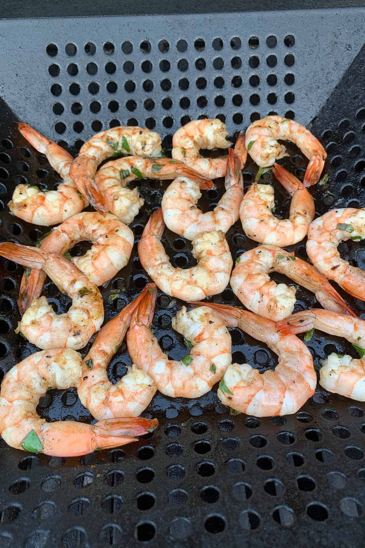 Cooked shrimp in a grill basket.