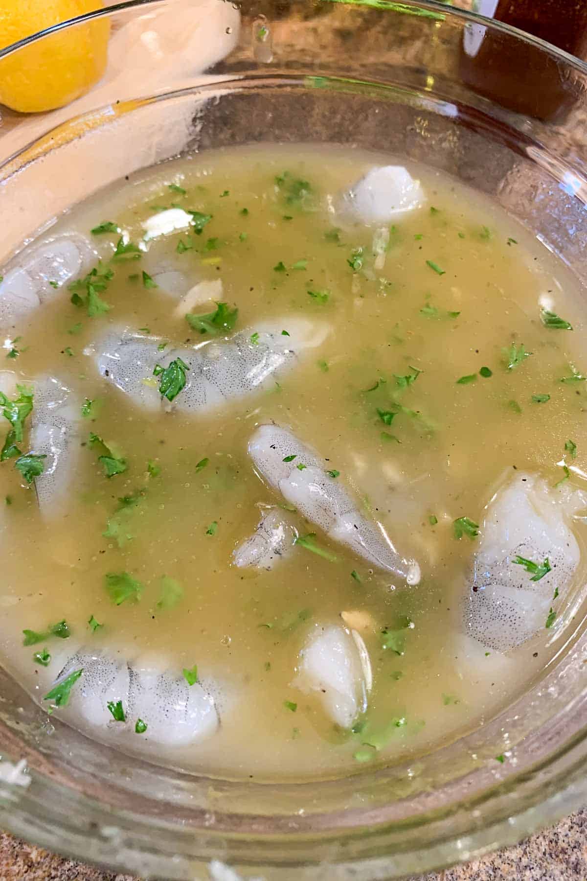 Shrimp in a bowl of lemon marinade.