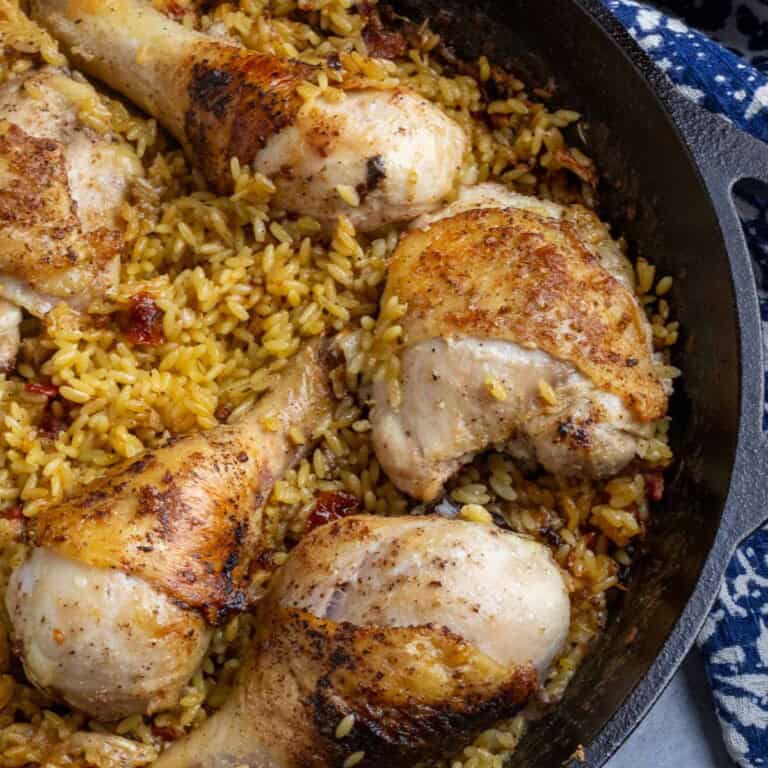 Chicken and orzo with sundried tomatoes in a cast iron skillet.