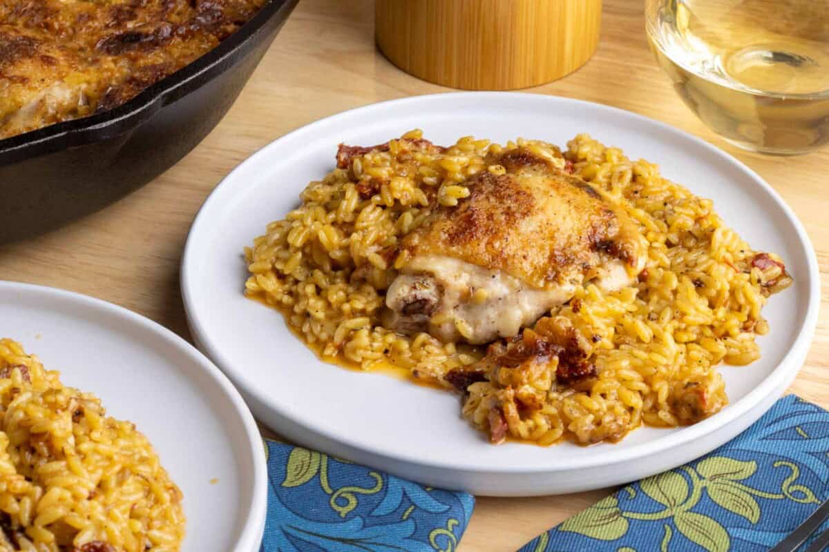 Chicken and orzo on a white plate with a floral napkin. 