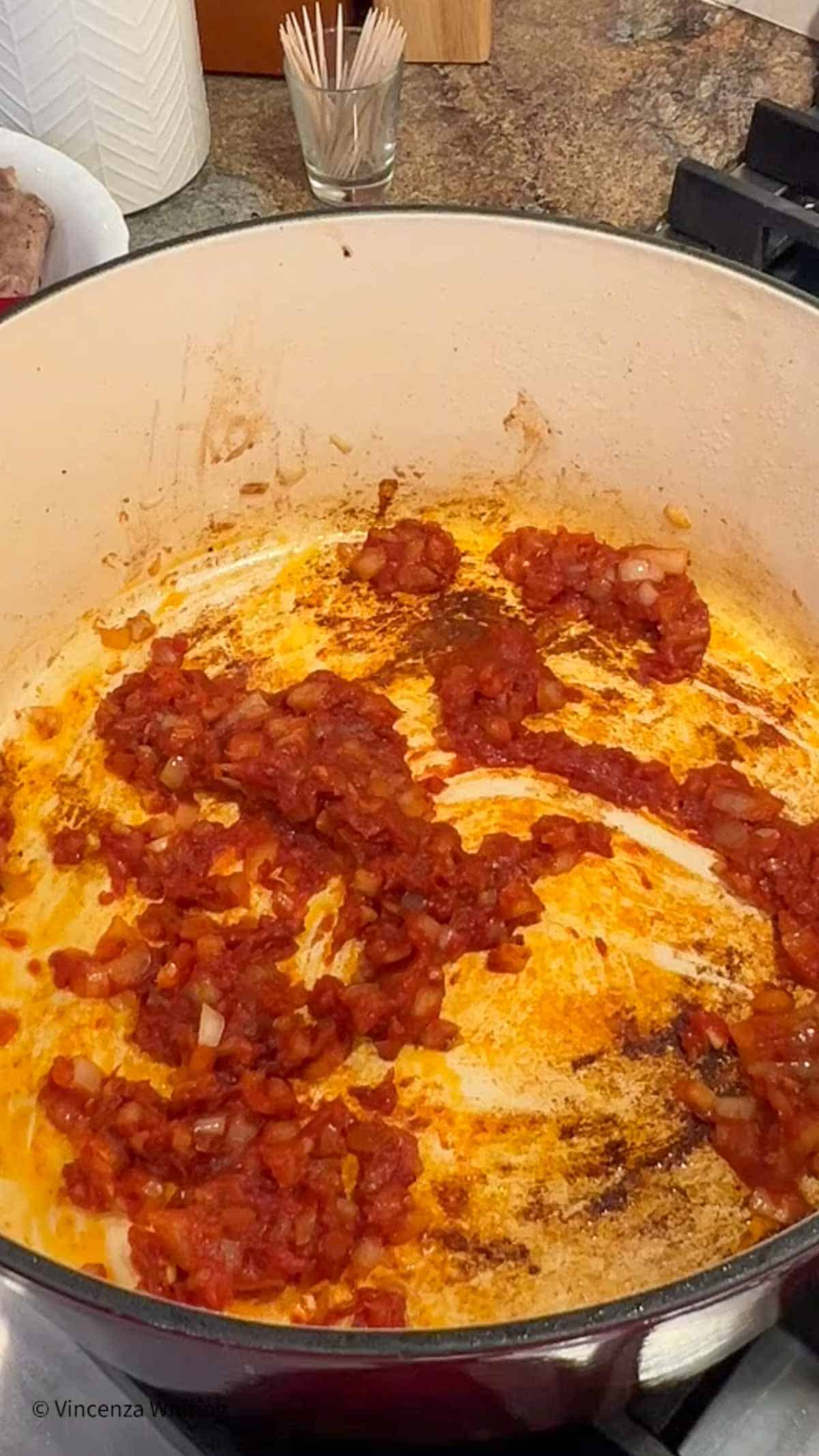 Onion and tomato paste in a Dutch oven.