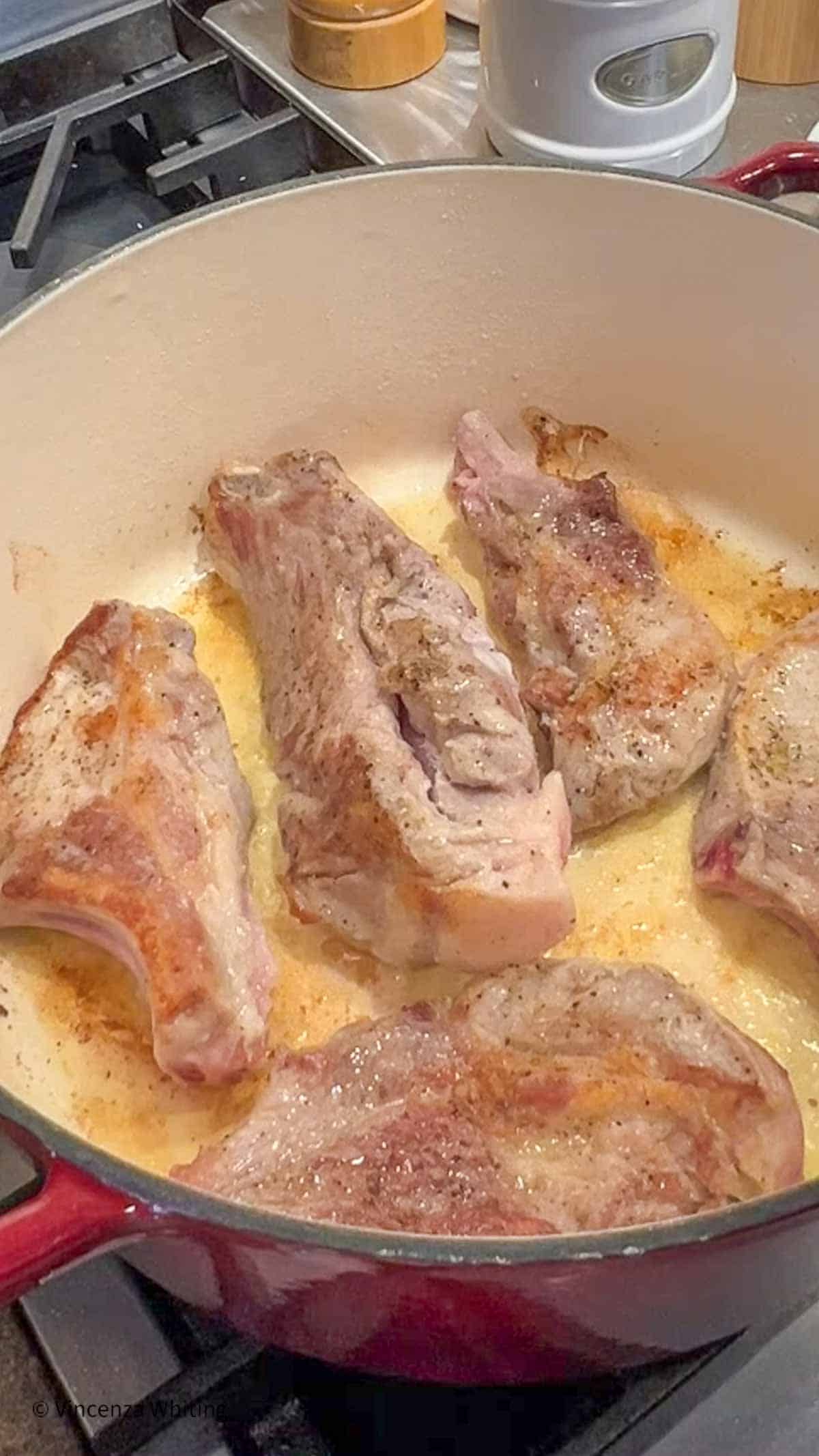 Browned pork ribs in a Dutch oven.