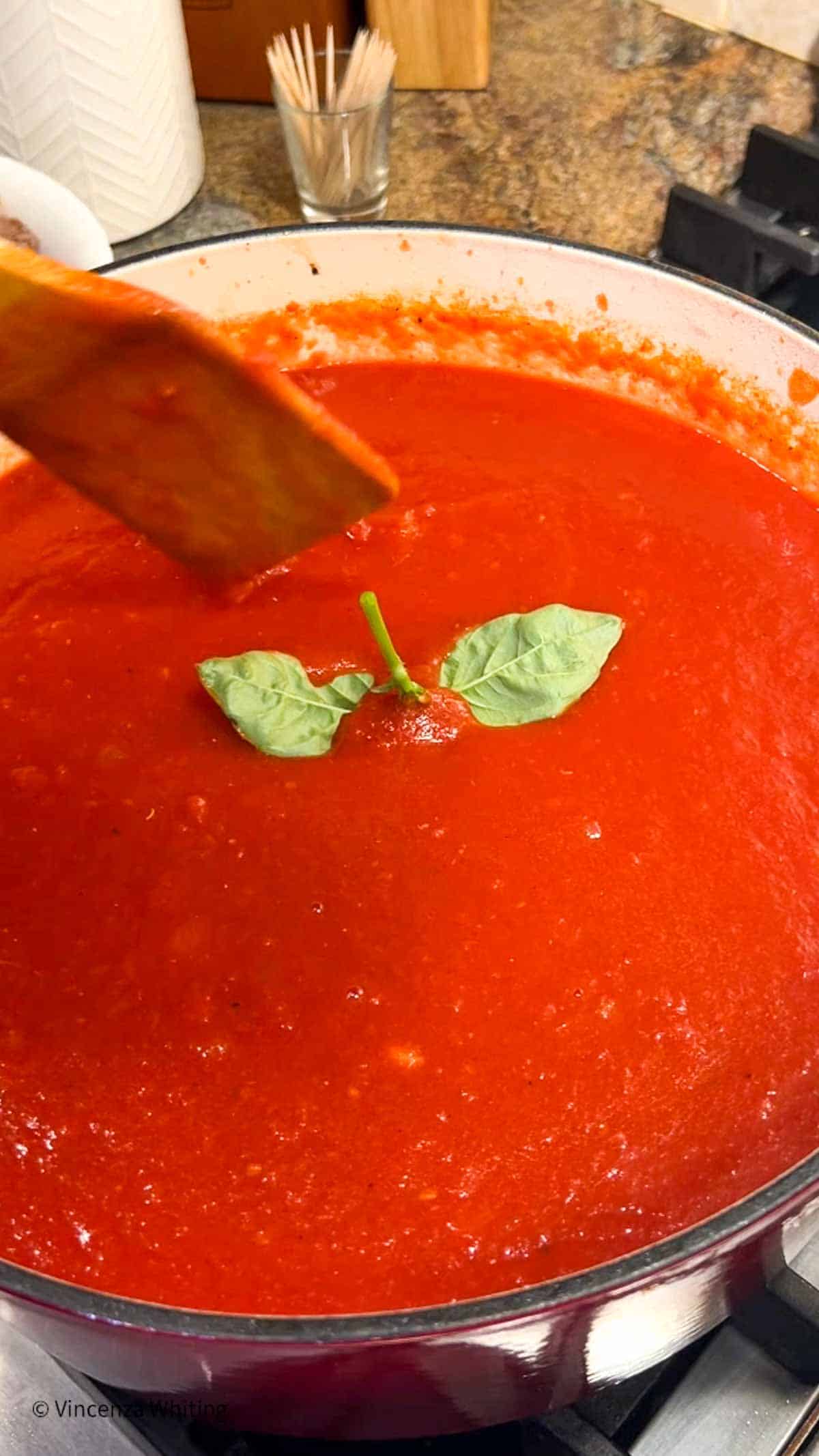 Tomato sauce with fresh basil in a Dutch oven.