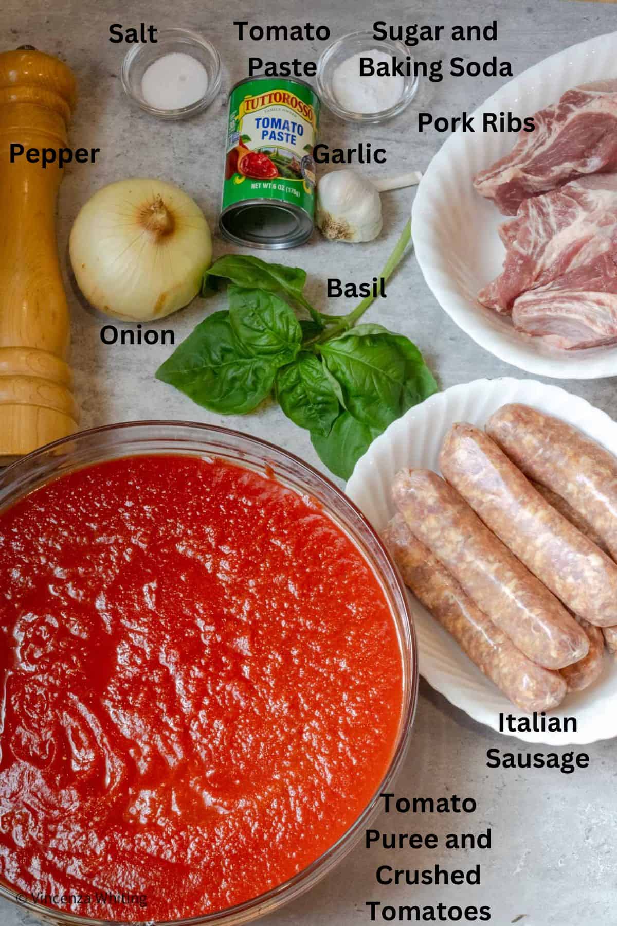 Ingredients for making a meat sauce with labels on a gray background.