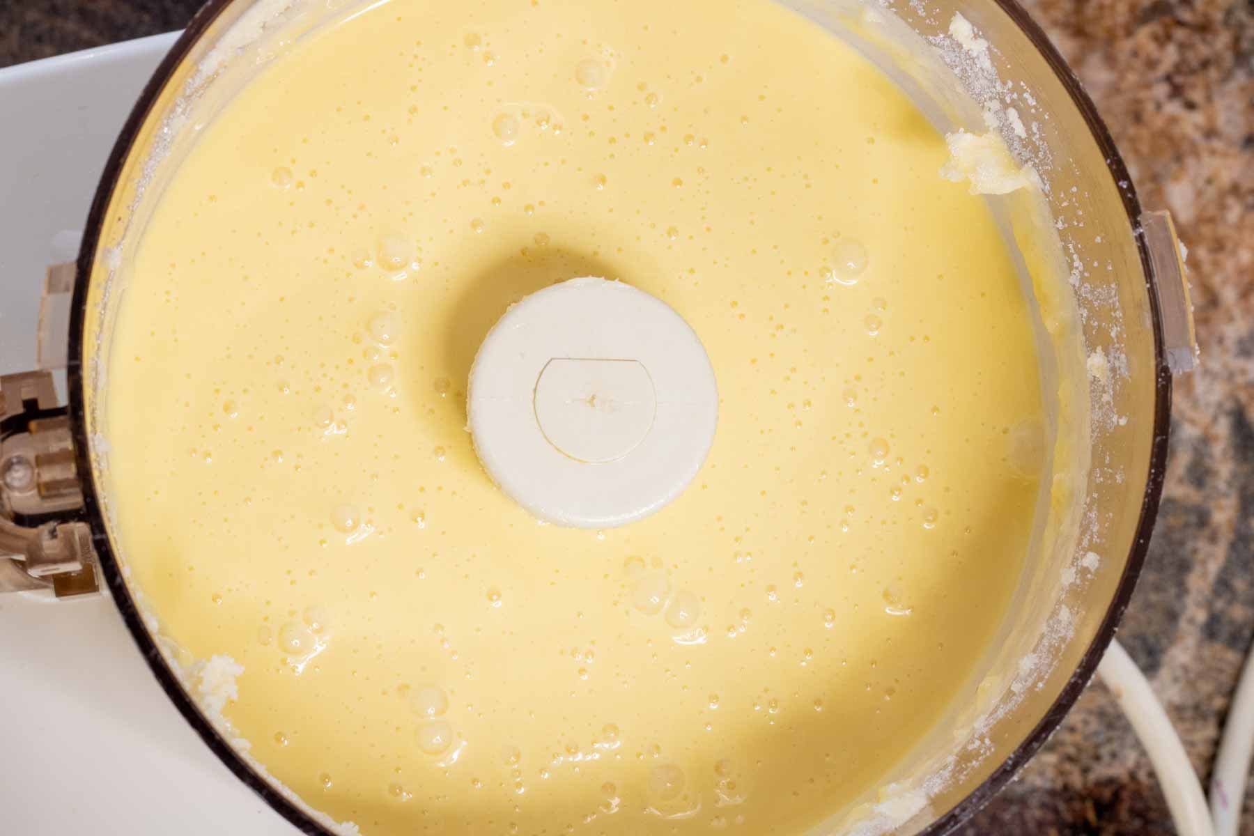Almond cake batter in the bowl of a food processor.