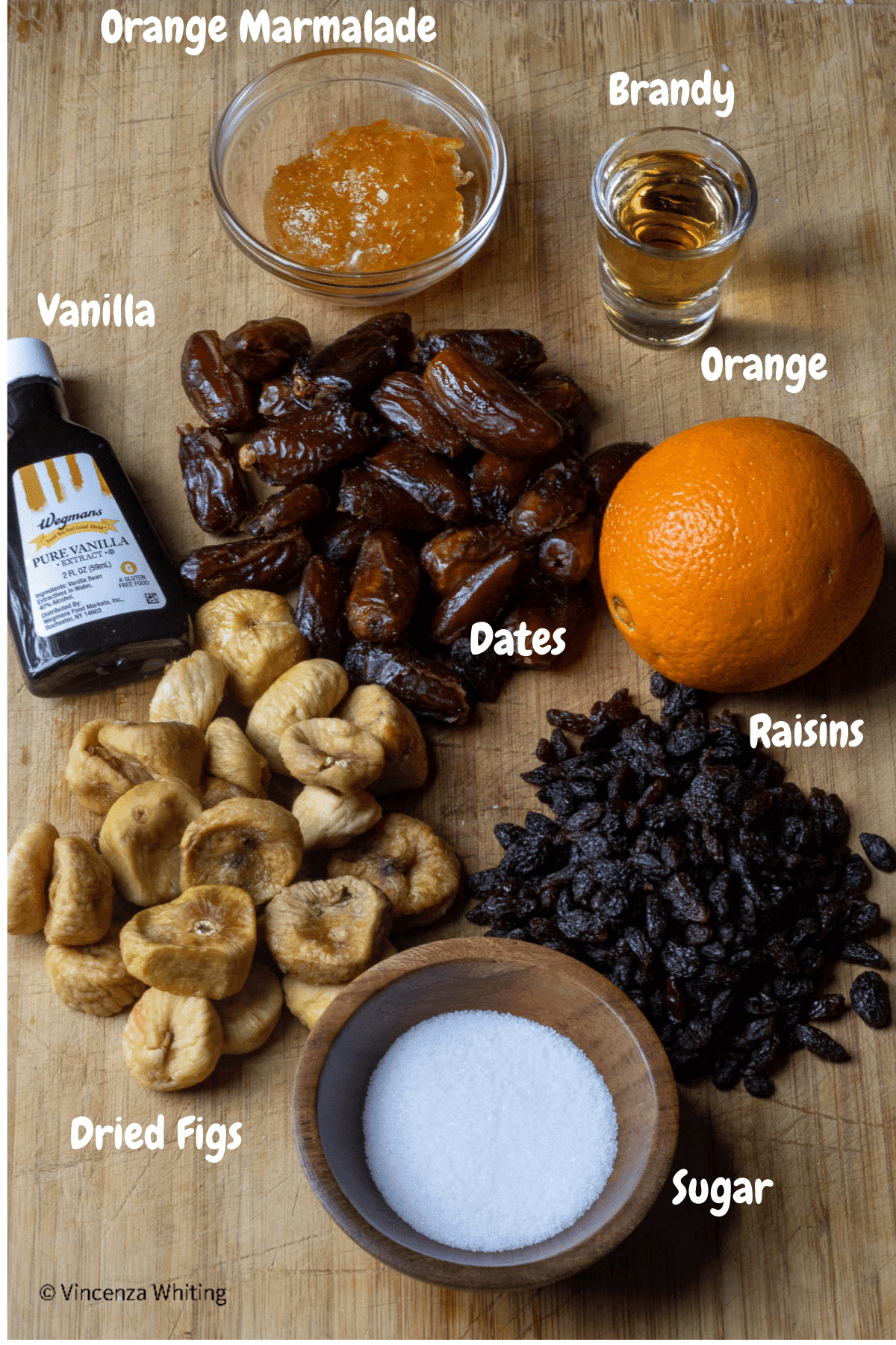 Ingredients for making fig cookie filling on a wood background with labels over each item.