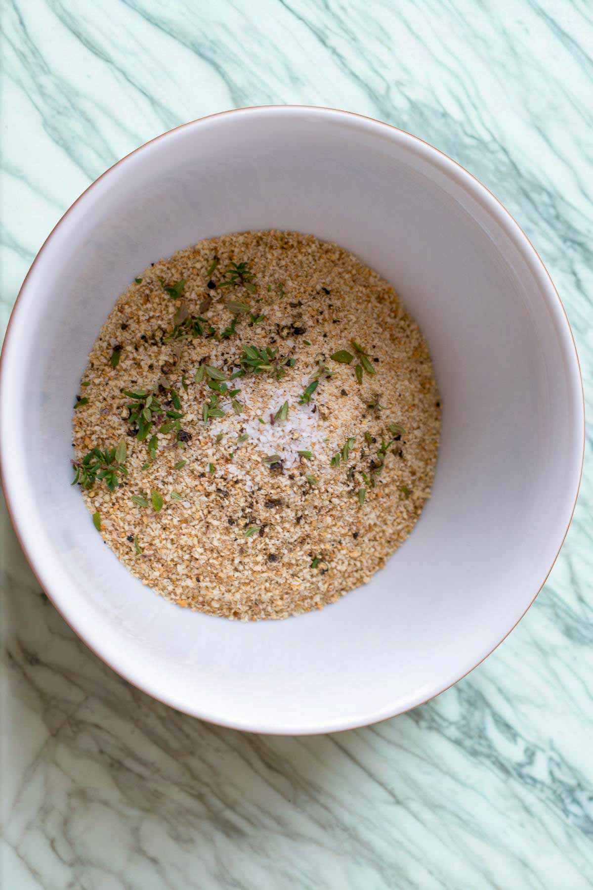Seasoned bread crumbs in a a white bowl.