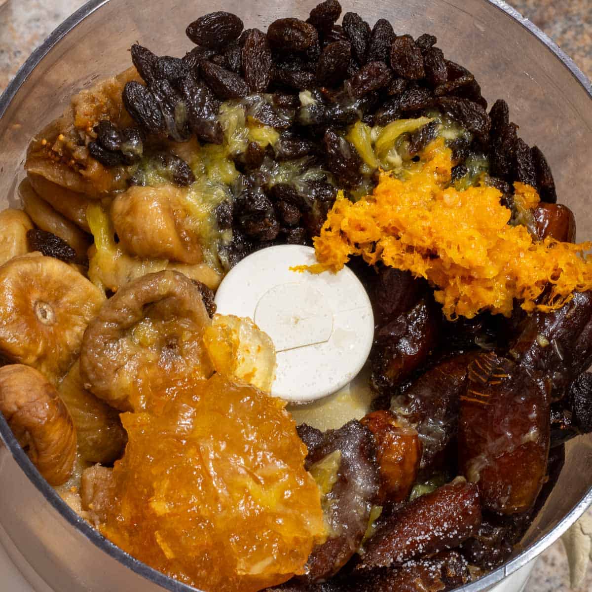 Dried fruits and marmalade in a food processor bowl.
