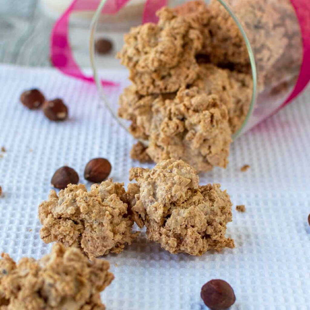 Hazelnut meringue cookies spilling out of a jar.