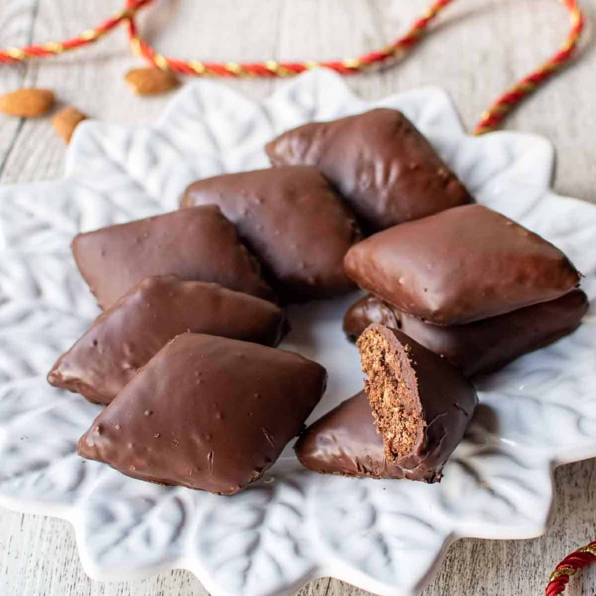 Square chocolate and nut cookies on a white plate. 