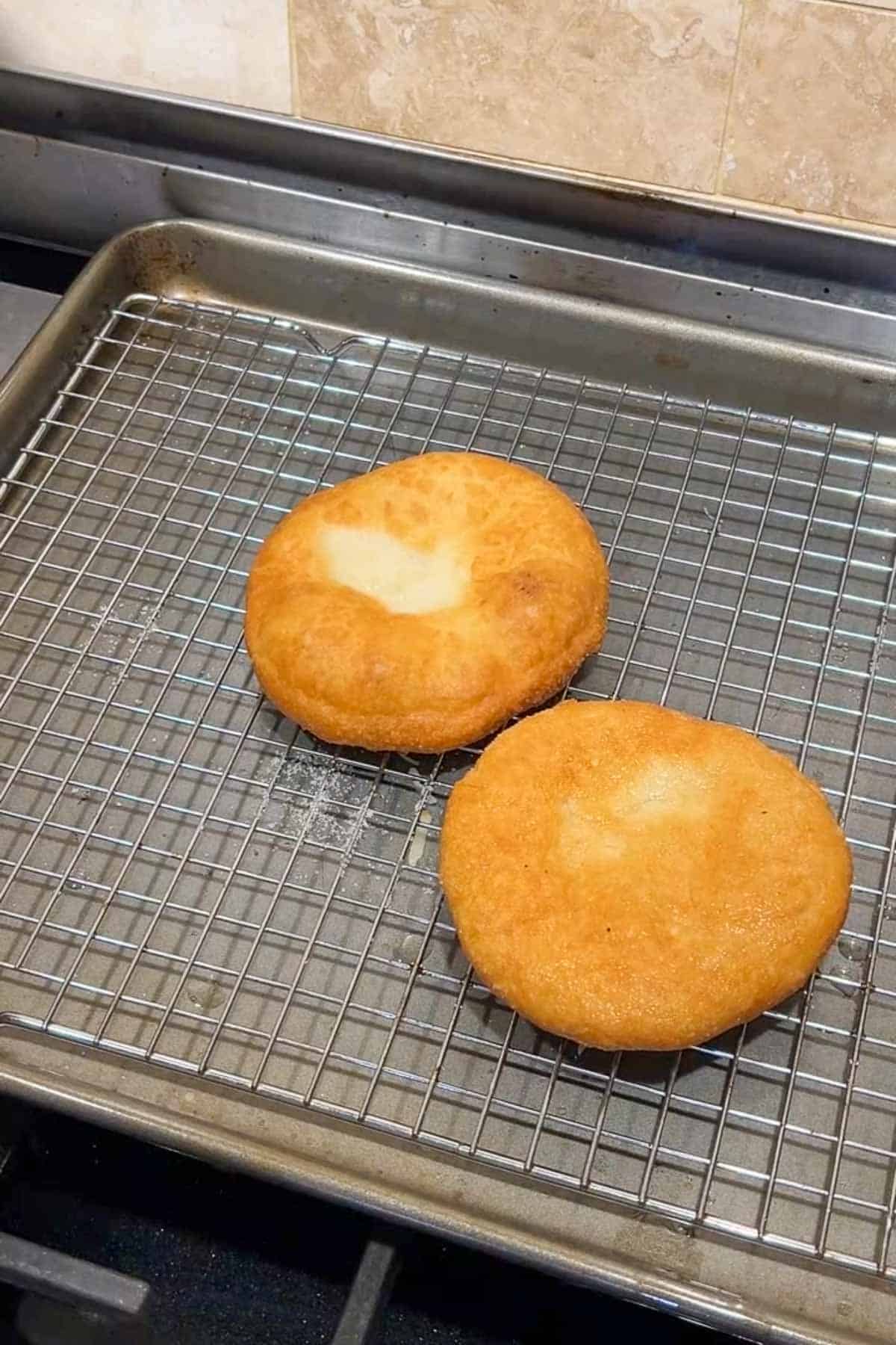 Two golden pizza frittas on a rack set over a baking sheet.