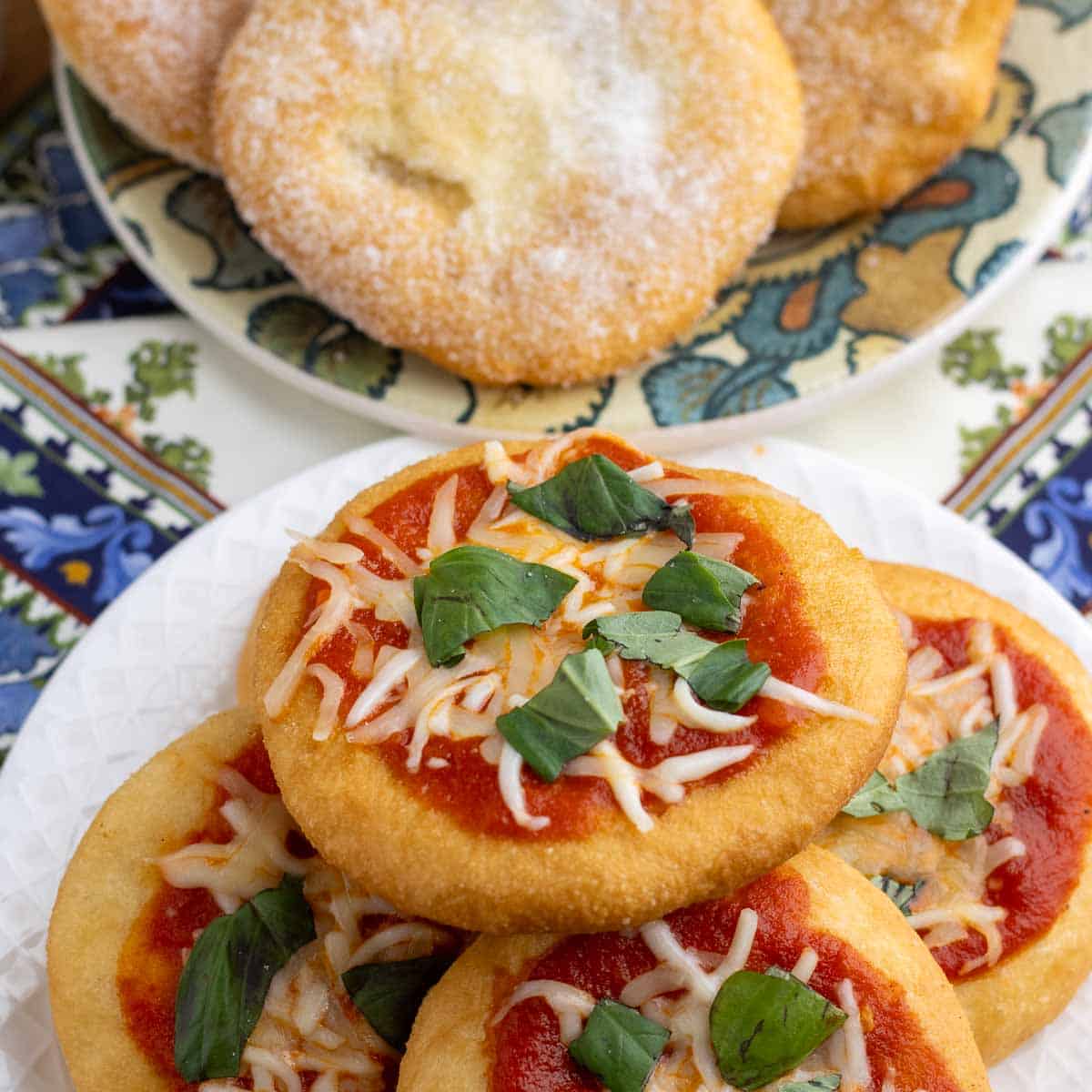 Two types of pizza fritta; a savory one with sauce and cheese and a sweet one with granulated sugar.
