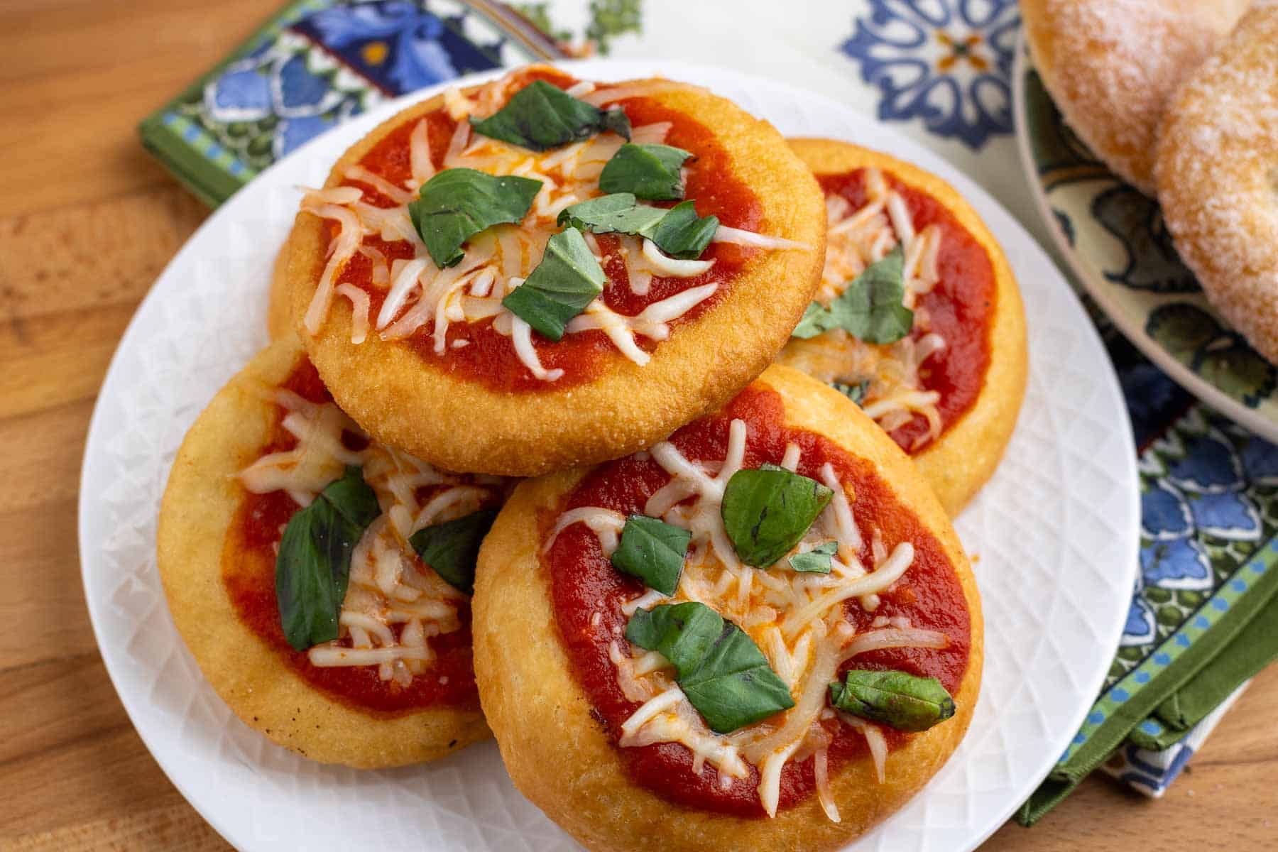 A plate of pizza fritta montanara with sauce and cheese.