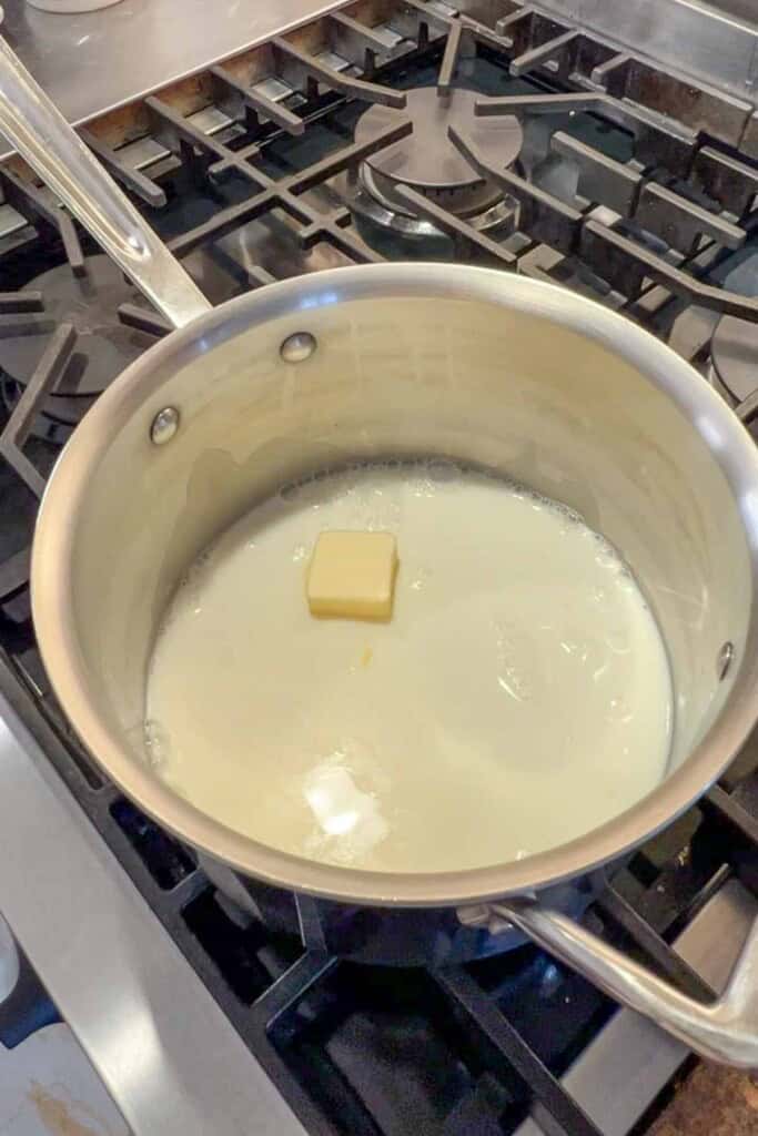 A pan with milk and a pat of butter in it.