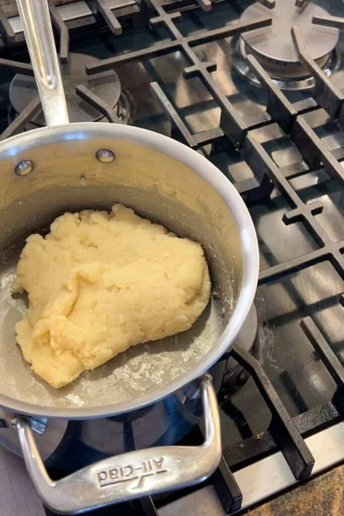 A pan with dough in it on a stove.