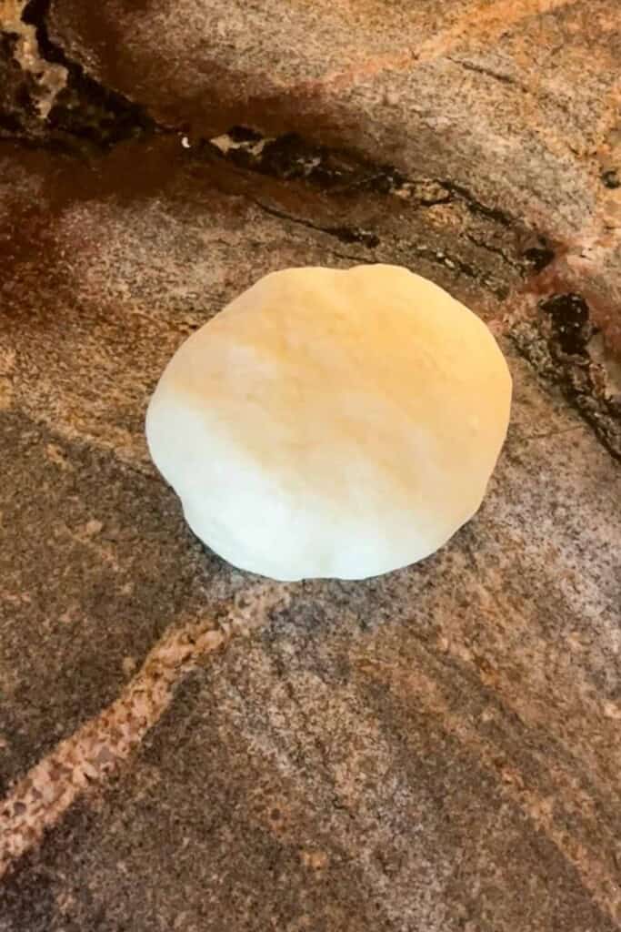 A ball of dough on a granite counter.