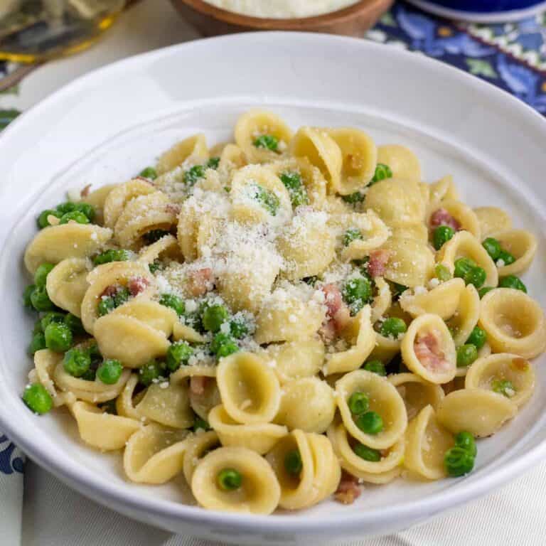 Pasta with peas and pancetta topped with grated cheese.